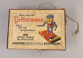 Die Schachtel ist rechteckig. Sie ist aus Pappe. Auf ihr steht: "Schau was der Elektromann alles aus sich machen kann." Das Bild zeigt ein Männchen. Es steht auf einer Batterie.