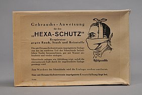 Das Etikett zeigte ein Gesicht. Das Gesicht trägt die Schutzmaske. Sie ist um den Kopf gewickelt.
