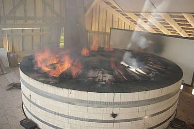 Der Ofen ist rund. In ihm liegen Kalksteine. Sie werden gebrannt.