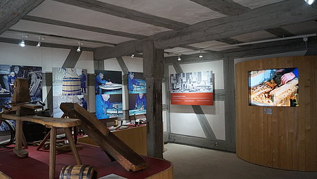 Verschiedenes Werkzeug aus Holz und Metall auf Ausstellungselement und Videostation