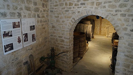 Text- und Fototafeln und historische Weinfässer