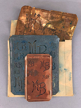 Die drei Schablonen zeigen Buchstaben. Die Buchstaben sind M und B. Sie sind mehrfach auf jeder Schablone zu sehen.