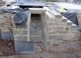 fertige Treppe mit schmalem, gemauertem Durchlass hinter der Treppe