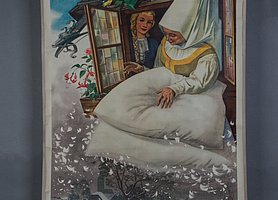 Auf dem Bild ist ein Haus. Aus dem Fenster schauen zwei Frauen. Sie schütteln Kissen aus. Aus den Kissen kommen Federn. Die Federn werden zu Schnee. Unten ist eine Winterlandschaft zu sehen.