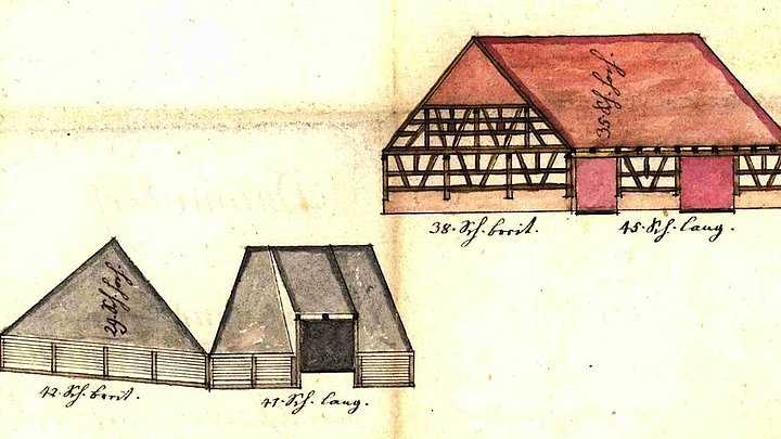 Fotoaufnahme des Bauplans von einem Fachwerk. Oben ist das Haus als Ganzes gezeichnet, in der Mitte die Giebelseiten. Unten sind zwei Grundrisse sowie je ein Maßstab für Längen und für Winkel abgebildet. Die Bezeichnungen an den Zeichnungen sind handschriftlich.