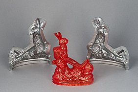 Auf dem Bild ist eine Gussform. Sie ist aus Aluminium. Sie ist aus zwei Hälften. Mit ihr kann man einen Zuckerhasen gießen. Der Zuckerhase ist rot. Er hat eine Schubkarre.