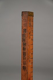Auf dem Stab sind Markierungen. Sie enthalten Jahreszahlen. In den Jahren wurde der Stab geprüft.