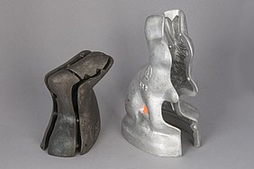 Die linke Form ist aus Eisen. Sie besteht aus vielen Teilen. Die rechte Form ist aus Aluminium. Mit beiden Formen kann man einen Osterhasen machen.