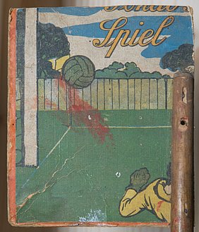 Der Flügel ist Teil des Pinseltauchapparats. Er ist aus Pappe gefertigt. Die Pappe kommt von einer Verpackung. In der Verpackung war ein Tipp-Kick-Spiel.