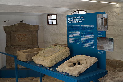 Vier Bauelemente aus Naturstein auf Ausstellungselement