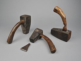 Die drei Hämmer haben kurze Stiele. Die Stiele sind aus Holz. Sie sind gebogen.