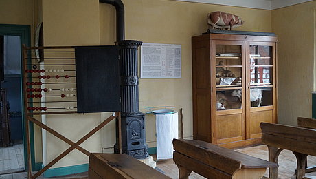 Großer Rechenschieber und Schulschrank mit ausgestopften Tieren im Klassenzimmer