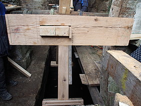 Diese Winkel, die in der Schmiede des Museumsbauhofs gefertigt wurden, halten das Kopfholz fest an der Speiche. Sie sind in ihren Maßen genau auf die Bauteile des Mühlrads abgestimmt.