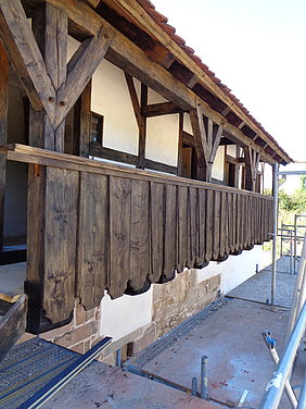 Bretterschaltung an einem Gang an der Außenseite des Hauses im 1. OG, davor noch ein Gerüst