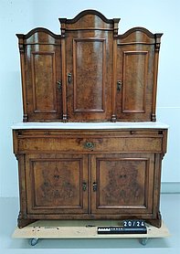 Das Wohnzimmerbuffet ist ein Schrank. Er besteht aus einem Unterschrank und einem Aufsatz. Der Aufsatz ist oben bogenförmig.