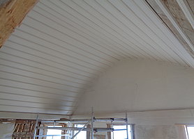 Tonnenförmig verbretterte Decke mit weißen Anstrich