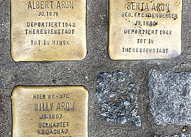 Drei goldene Stolpersteine in Bamberg mit den Namen der Familie Aron.