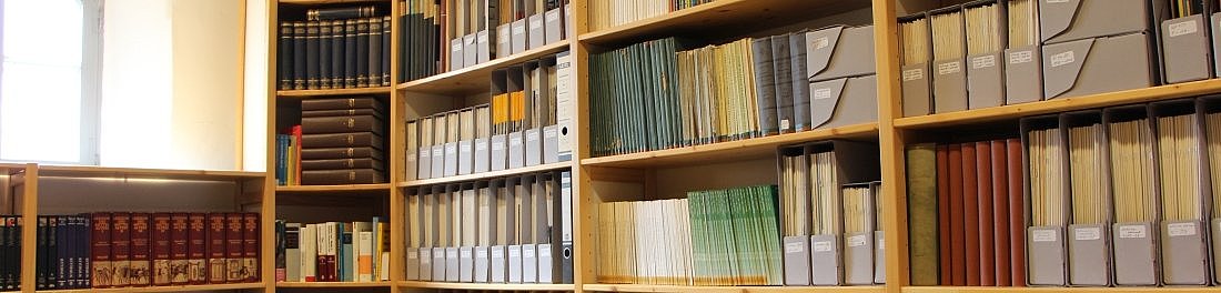 fünf Bücherregale, vollgefüllt mit zahlreichen Büchern und Zeitschriften, seuberlich sortiert