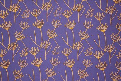 Das Muster ist eine gelbe Blume. Sie ist auf blauem Grund.