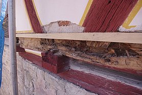 Das Fachwerk besteht aus Holz. Ein Holzteil ist feucht geworden. Es ist jetzt kaputt.
