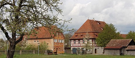Das Gasthaus aus Oberamfrach, ein imposantes Fachwerkgebäude, daneben links das Korbhaus aus Knittelsbach, gelb verputztes, kleines Fachwerkhaus. Vor dem Gasthaus eine Kegelbahn