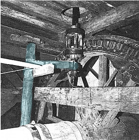 Technikdetail aus der traditionellen Mühltechnik: Kammrad und Kolben treiben das Mühleisen an, dadurch wird die Mechanik des Beutelkastens aktiviert