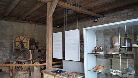 Historische Bandsäge und Ausstellungsvitrine mit verschiedenen Holzschuhtypen