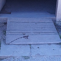 FFM_Mittelalter_Hoefstetten_Rampe Fotoaufnahme der Türschwelle im Eingangsbereich des Bauernhauses aus Höfstetten am aktuellen Standort. Vor der Schwelle liegt eine Rampe aus Holz, die der Schwellenüberbrückung dient. Das Haus gehört zum mittelalterlichen Bauernhof.
