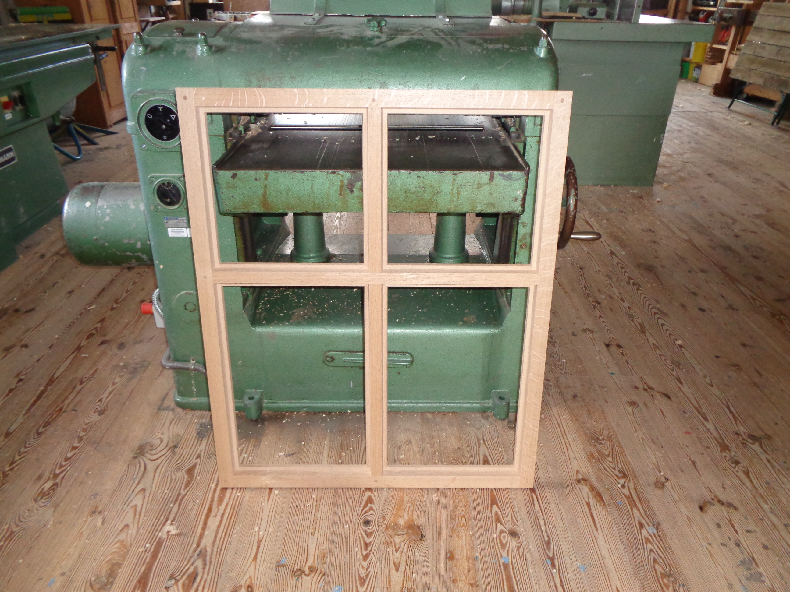 Roher Fensterstock mit Kreuzstock vor einer Hobelmaschine