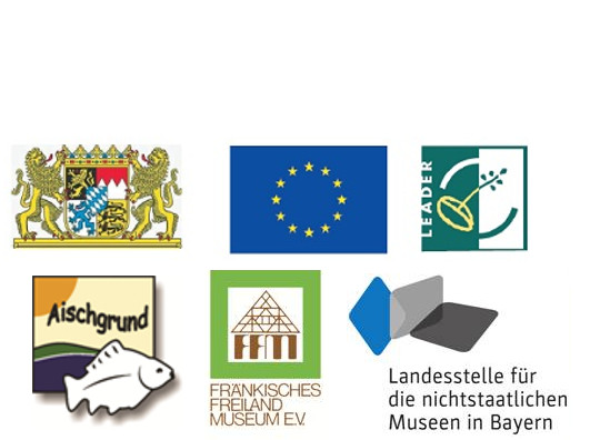 FFM_Foerderlogos Abbildung der Logos bzw. Wappen von sechs Förderern. Gezeigt wird das Wappen des Freistaat Bayern, das der EU und die Logos von LEADER, Lokale Aktionsgruppe Aischgrund e.V., Fränkisches Freilandmuseum e.V. und Landesstelle für nichtstaatliche Museen in Bayern.